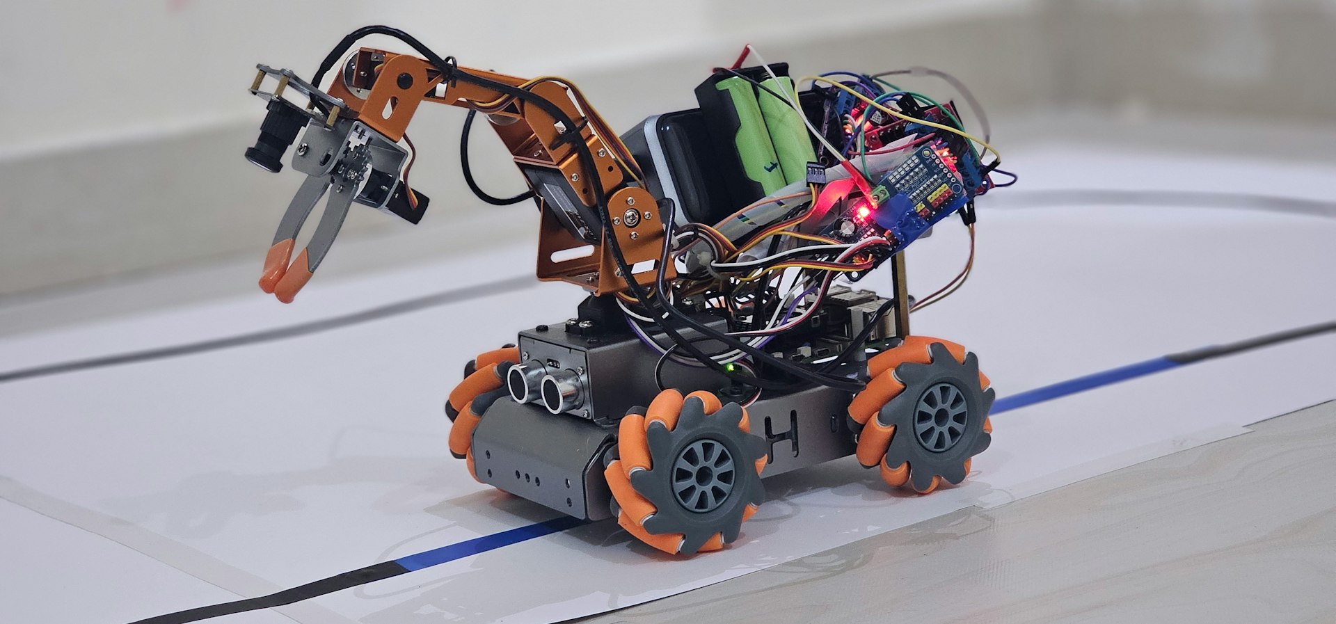 Complex robot with orange wheels and a robotic arm